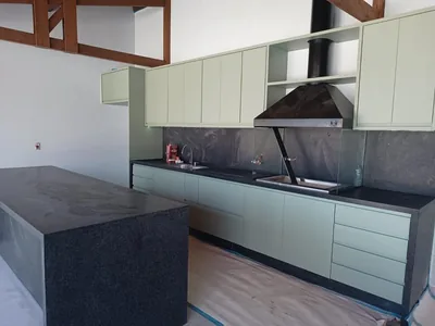 Área gourmet em verde com ilha e churrasqueira, executada em Campinas