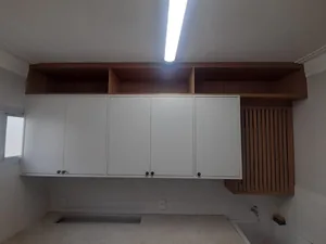 Área de serviço planejada com armários superiores e bancada de apoio, executada em Campinas