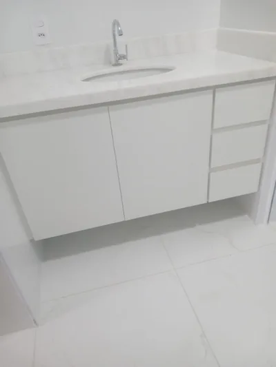 Banheiro planejado com gabinete branco e bancada, executado em Campinas