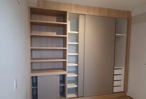 Guarda-roupa planejado com porta de correr aberta, revelando prateleiras, cabideiro e gaveteiro internos, executado em Campinas