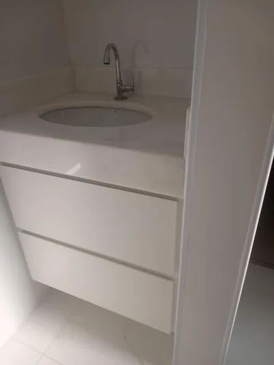 Lavabo planejado com gabinete branco e cuba de apoio, executado em Campinas