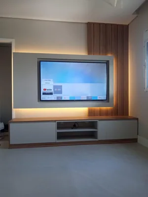 Painel de home theater em madeira com iluminação LED e rack suspenso, executado em Campinas