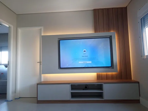Painel de TV em madeira com iluminação LED atrás da TV, executado em Campinas